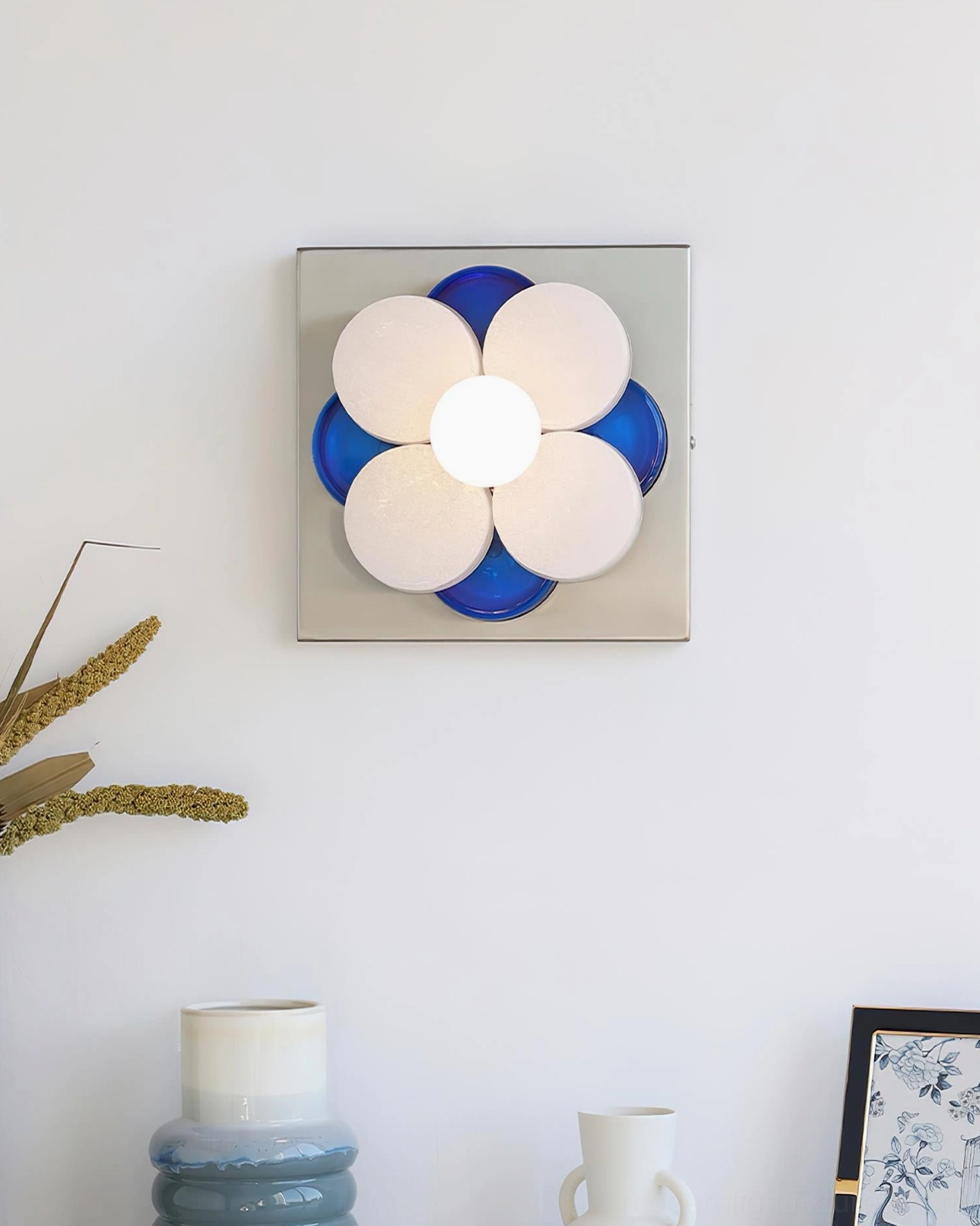 Violetta flower wall sconce frontal view with white frosted petals and blue details on chrome base, boho minimalist interior
