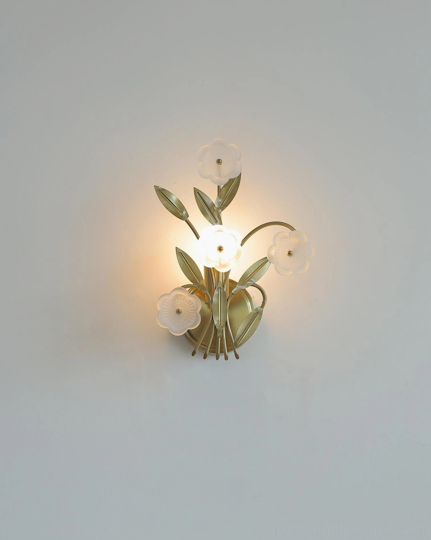 Virella floral wall sconce illuminated on gray wall, close-up showcasing glowing frosted glass flower accents