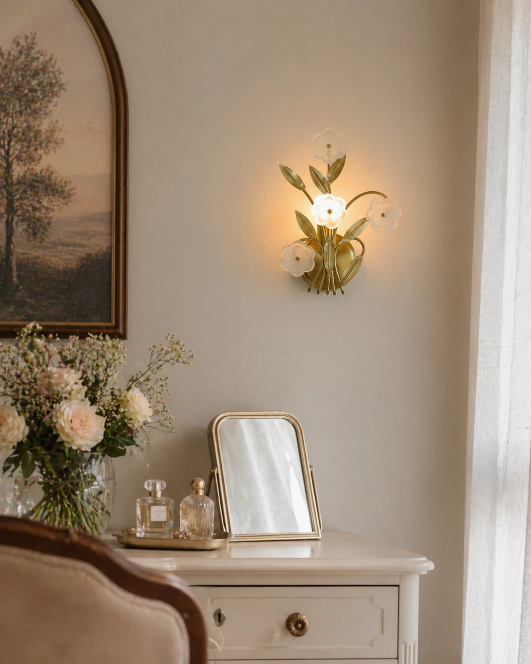 Virella wall sconce in bedroom vanity corner with warm glow, styled with floral table arrangement and decor