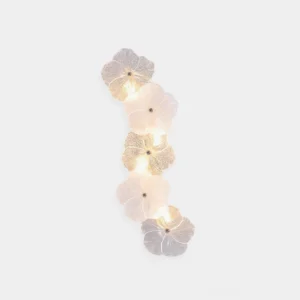 Virelle floral wall sconce with frosted and clear glass petals, warm ambient light, isolated product view