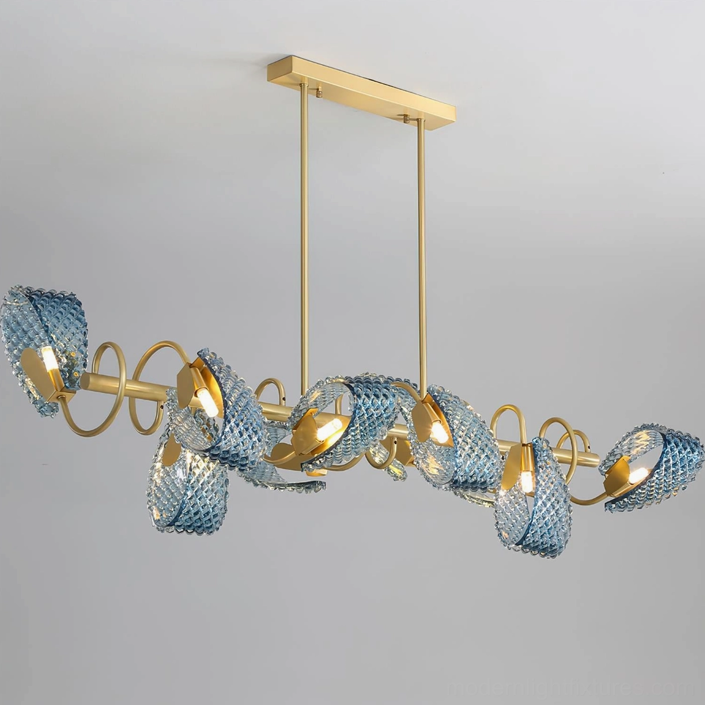 Virello contemporary linear chandelier with curved gold lamp arms and faceted blue glass covers, side angle perspective