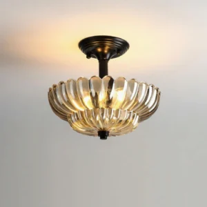 Virenza modern ceiling lamp illuminated, showing warm amber glow from scalloped glass petal design, close-up detail view