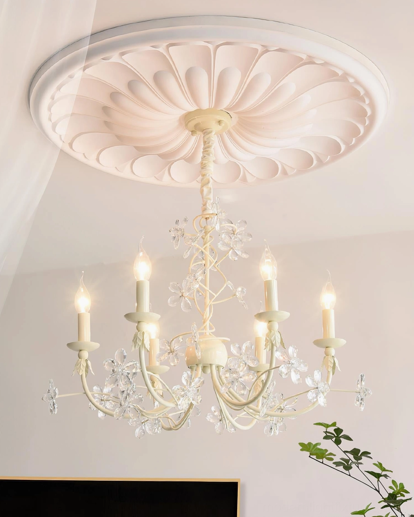Lit Vivette chandelier with crystal droplets and multicolored flowers mounted on ornamental ceiling medallion