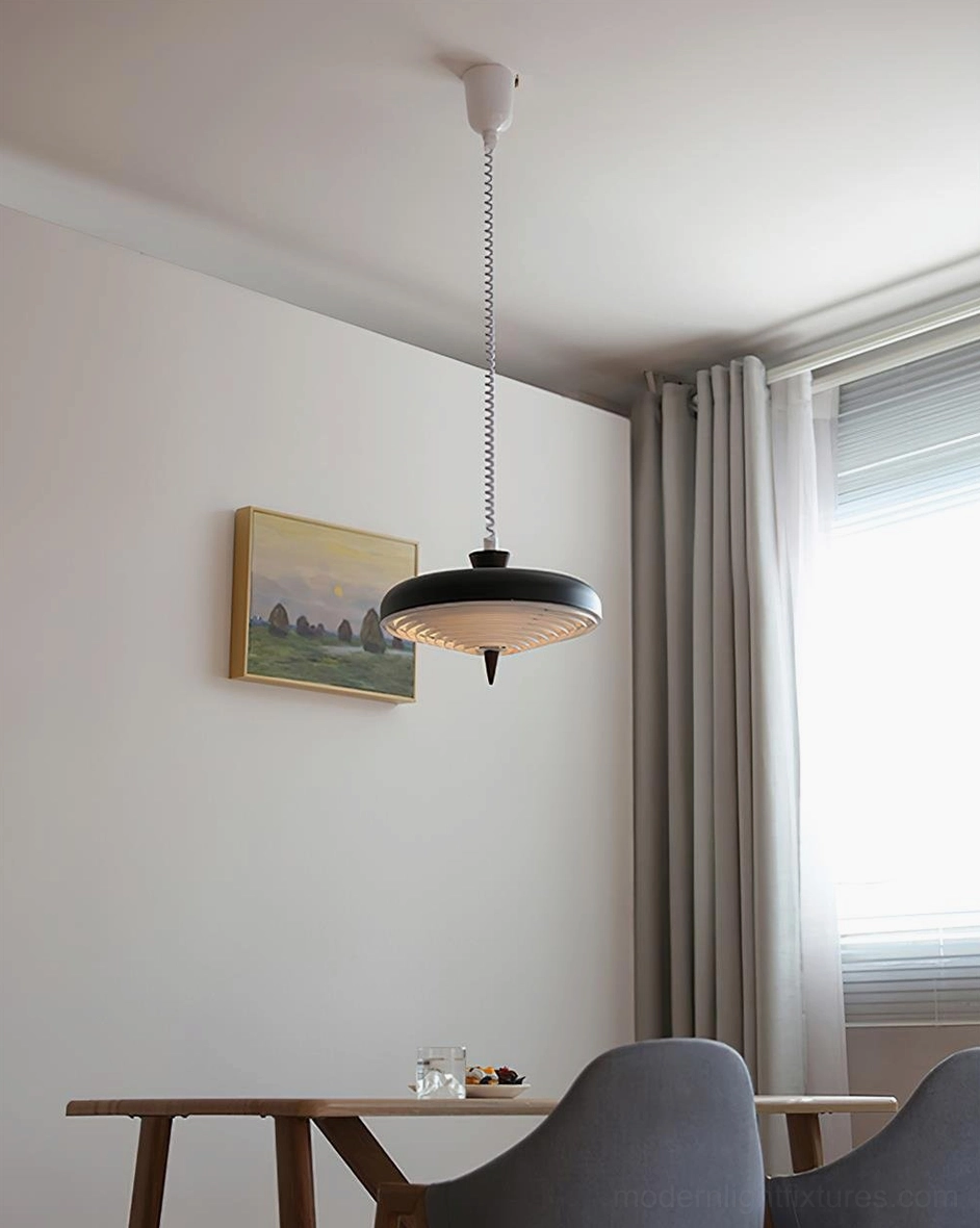 Black ribbed metal pendant light in dining room with table, chairs, and wall art installation