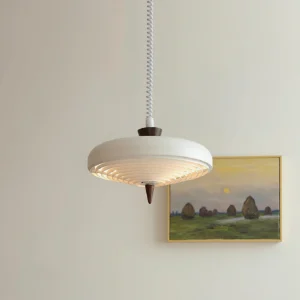 Modern white ribbed pendant lamp in interior setting with gallery wall and landscape painting backdrop