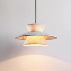 Close-up detail of Vortin pendant light showing travertine-inspired matte texture and two-tier disc design