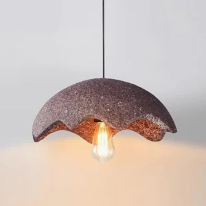 Close-up of red wabi-sabi pendant light fixture showing rough ceramic texture and vintage bulb detail