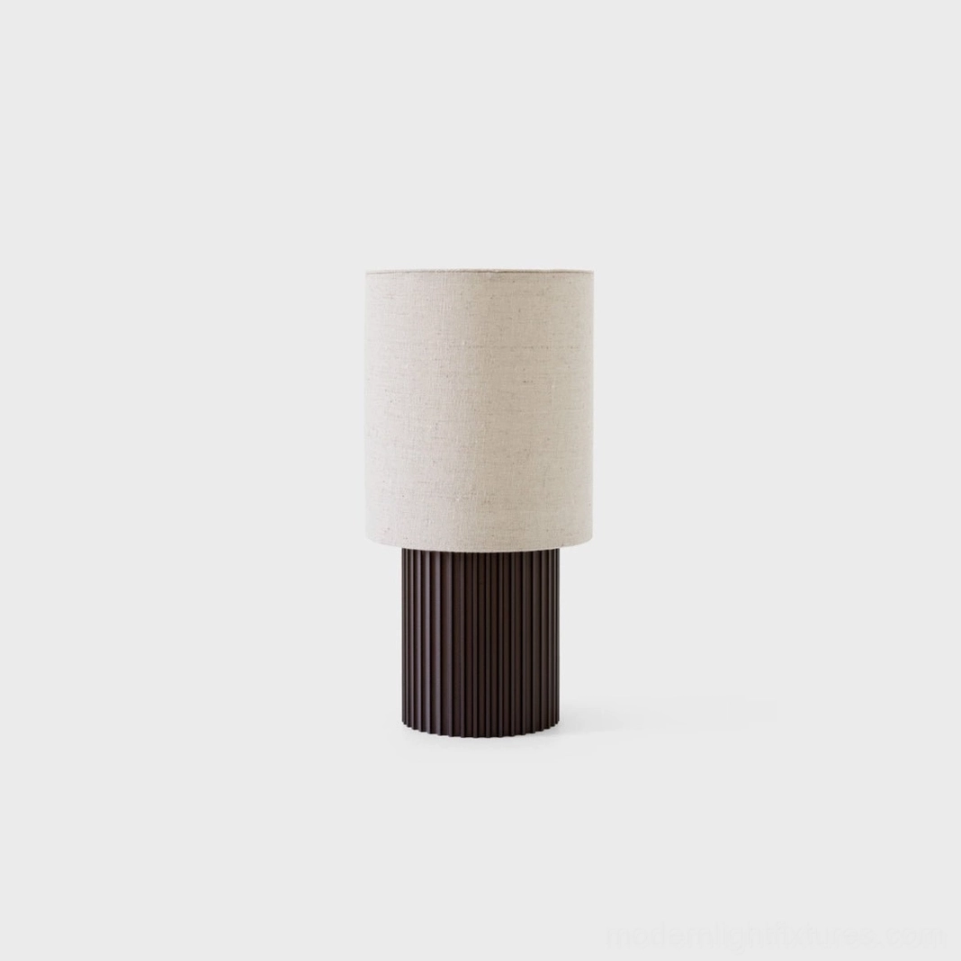 Wabi-sabi inspired table lamp with off-white fabric shade and fluted dark brown metal base, front studio view emphasizing minimalist philosophy