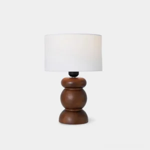 Modern wooden table lamp with white fabric shade and stacked turned wood base - front studio view