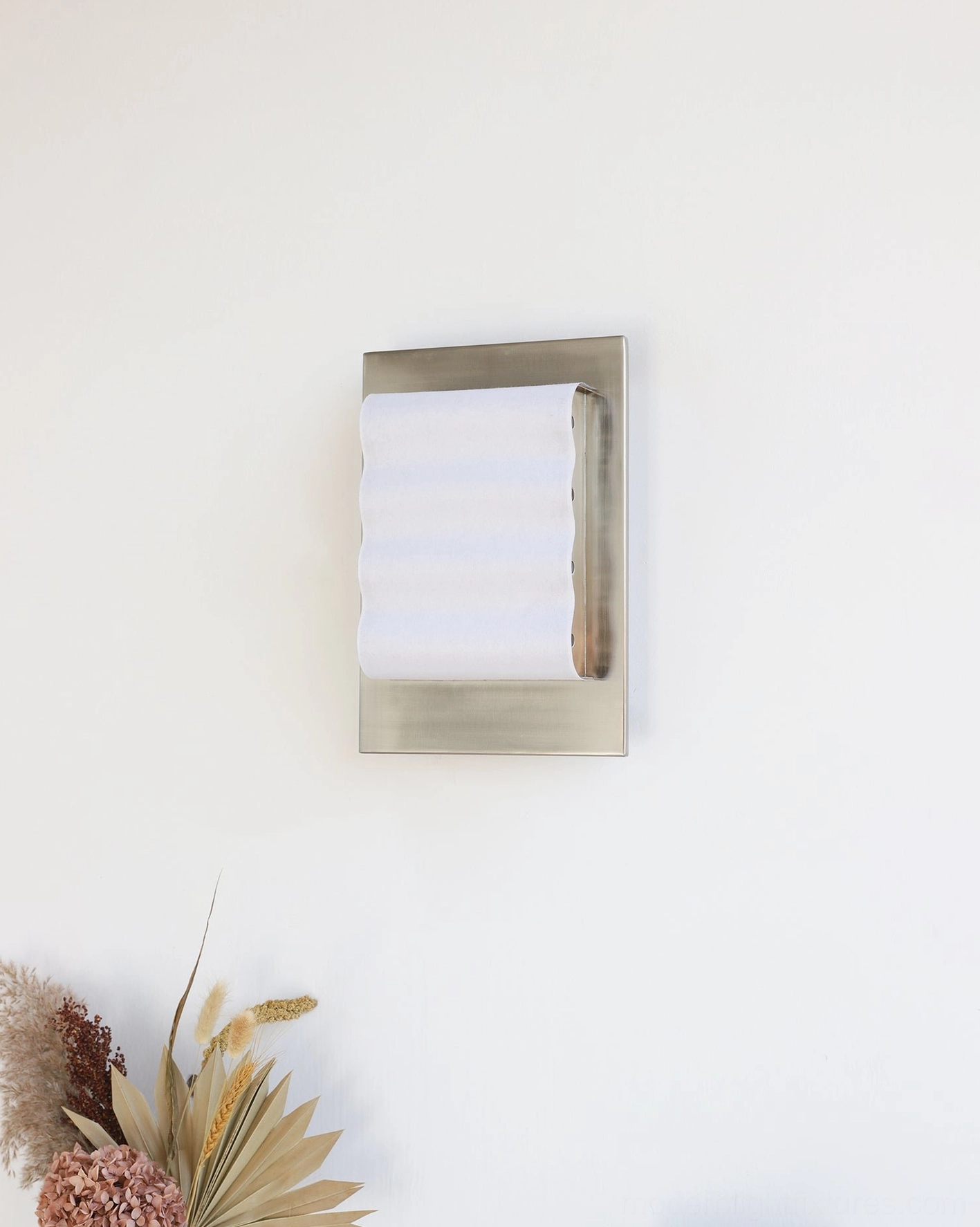 Contemporary wall sconce with compact flat shade and brushed silver frame mounted on residential wall