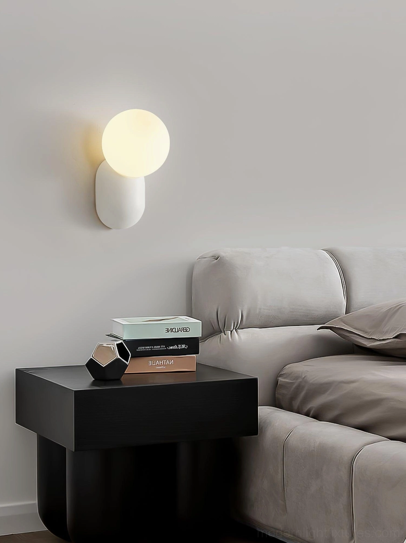 Modern wall sconce with warm light diffusion through frosted glass, creating soft ambient glow