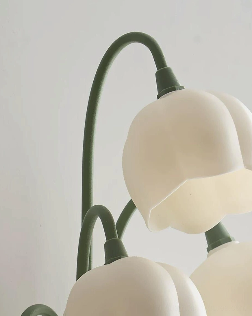 Wall-mounted floral sconce installation detail showing green iron body, stems, and mounting hardware on bedroom wall