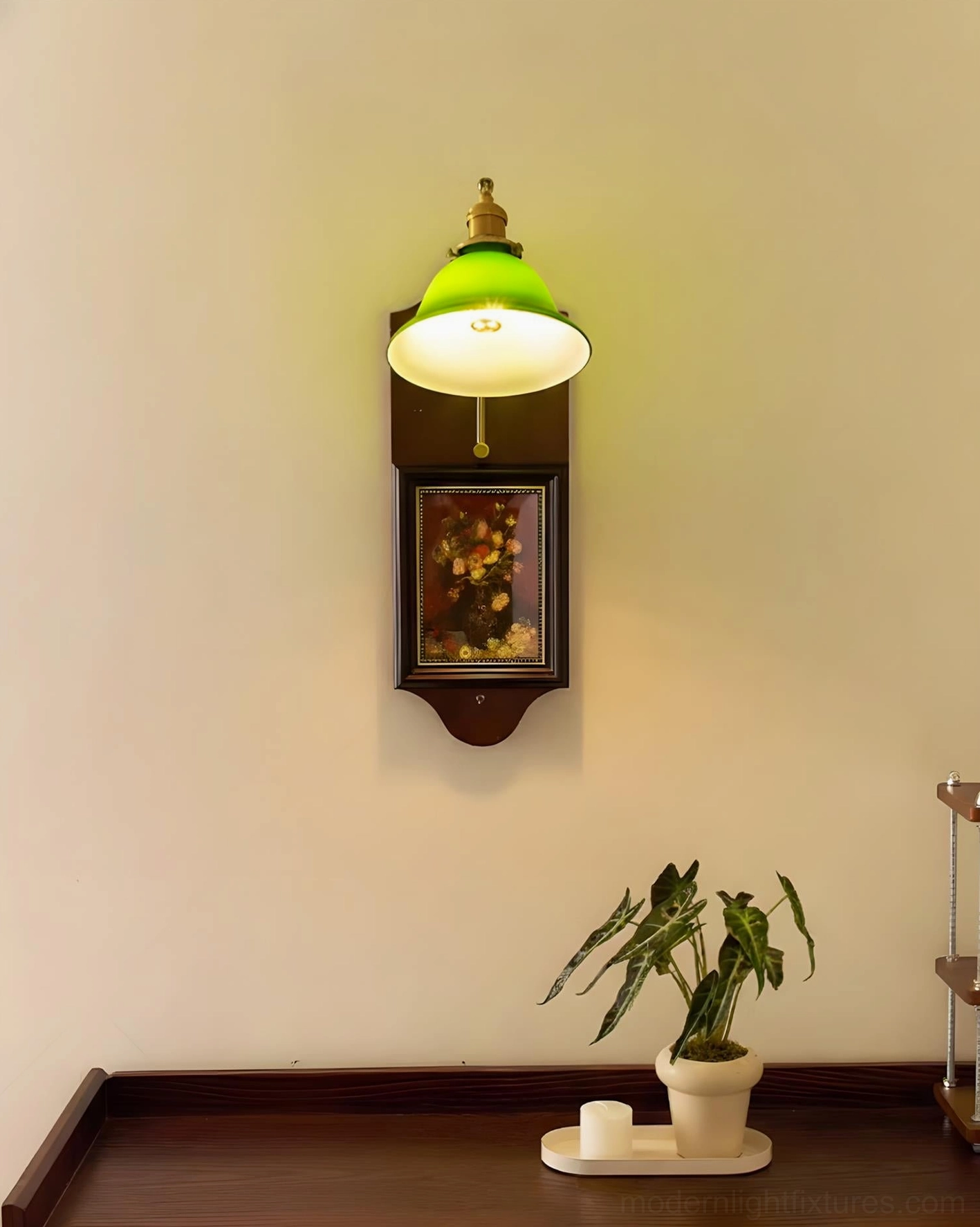 Top-front view of compact green glass wall sconce installed above wooden console table