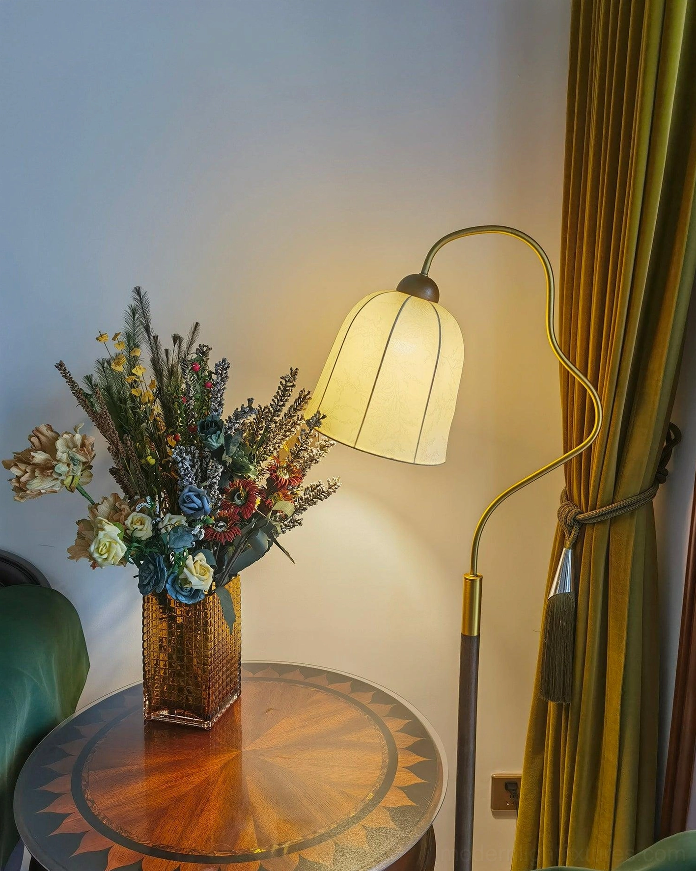 Full view of walnut arc floor lamp with curved arm extended over seating area, ambient lighting effect