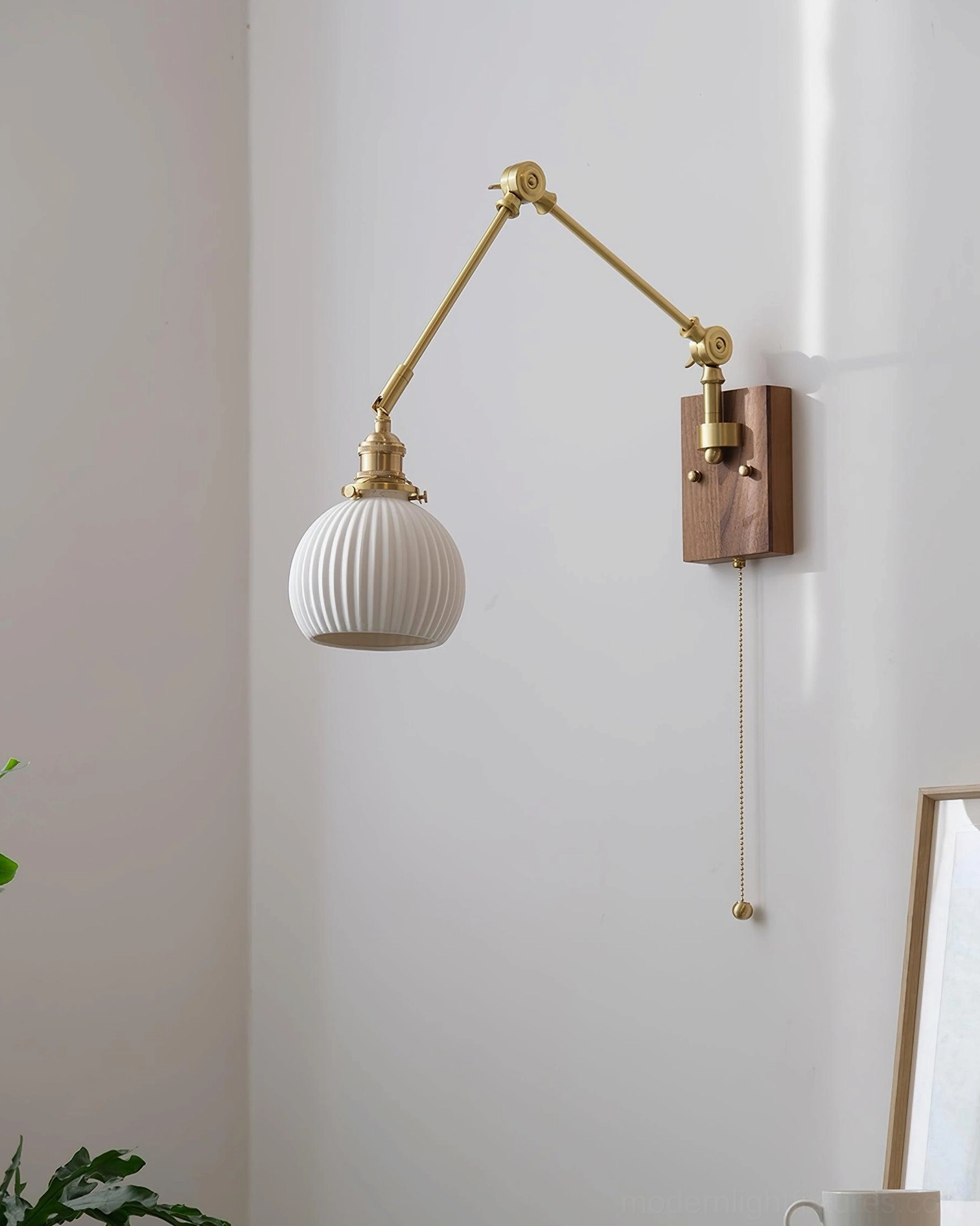 Swing arm wall sconce detail shot showing walnut wood base and brass hardware construction