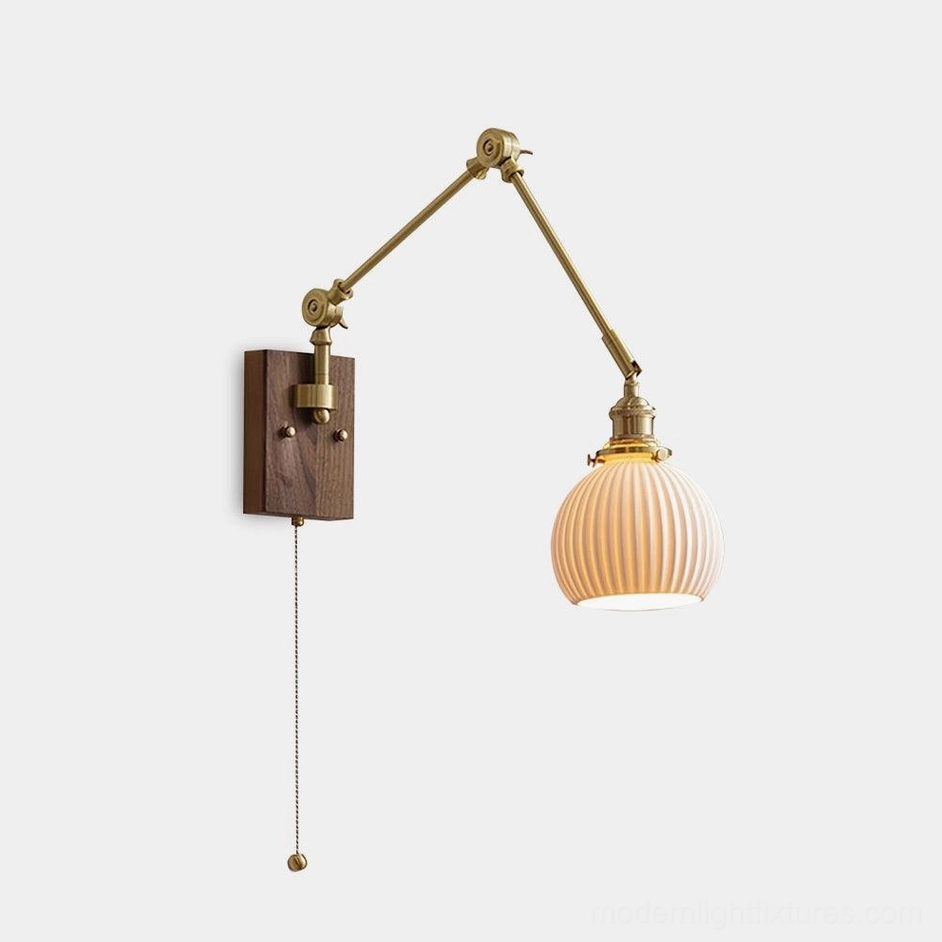 Modern walnut and brass swing arm wall sconce with ceramic ribbed shade, front studio view