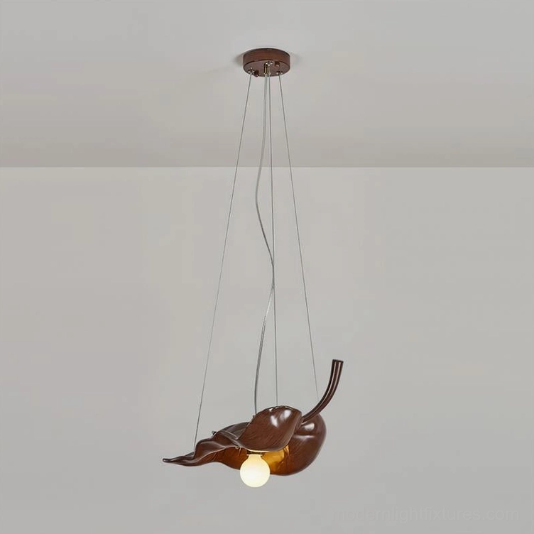 Dark brown maple leaf pendant light with visible suspension wires, side overhead studio view