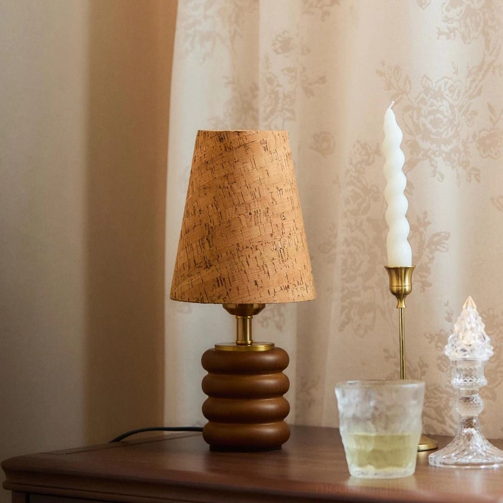 Compact walnut wood table lamp with cork shade on bedroom nightstand with brass holder and crystal decor