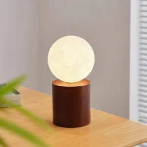 Walnut moon table lamp with warm illumination on bedroom side table, three-quarter angle view showing lit ambient glow