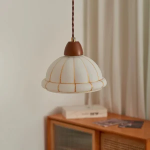 Modern pendant light fixture illuminated in cozy home interior with wooden furniture and warm decor