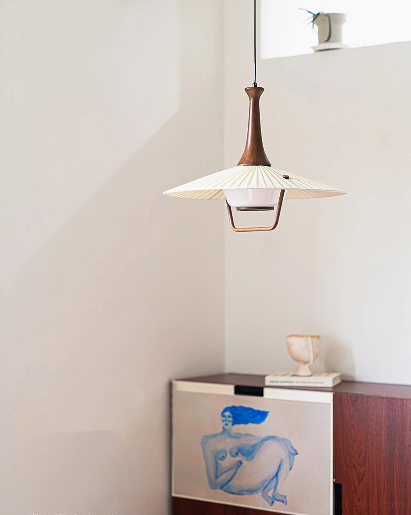 Walnut pleated pendant light softly illuminating dining space ambient evening lighting