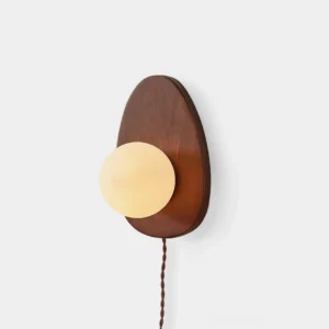 Walnut wood plug-in wall sconce with frosted glass globe on white background, mid-century modern design