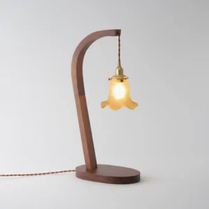 Wooden table lamp with twisted fabric power cord, side profile detail shot