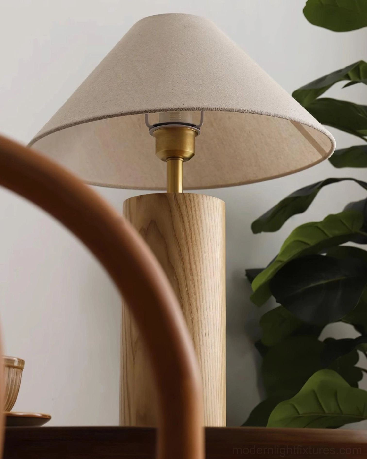 Complete view of modern table lamp in walnut finish with illuminated beige fabric shade