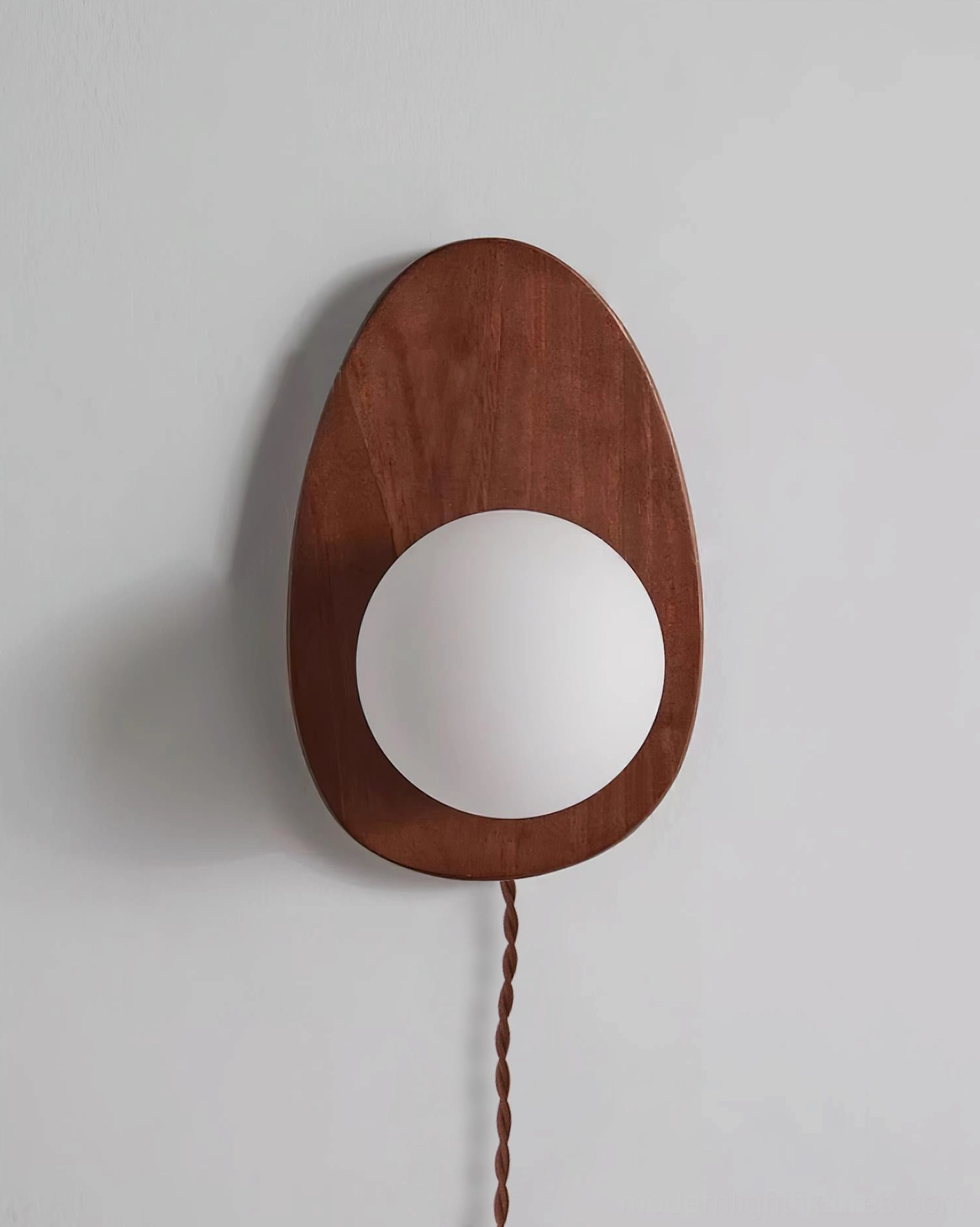 Walnut wood wall sconce with braided cord in modern interior, functional design statement piece