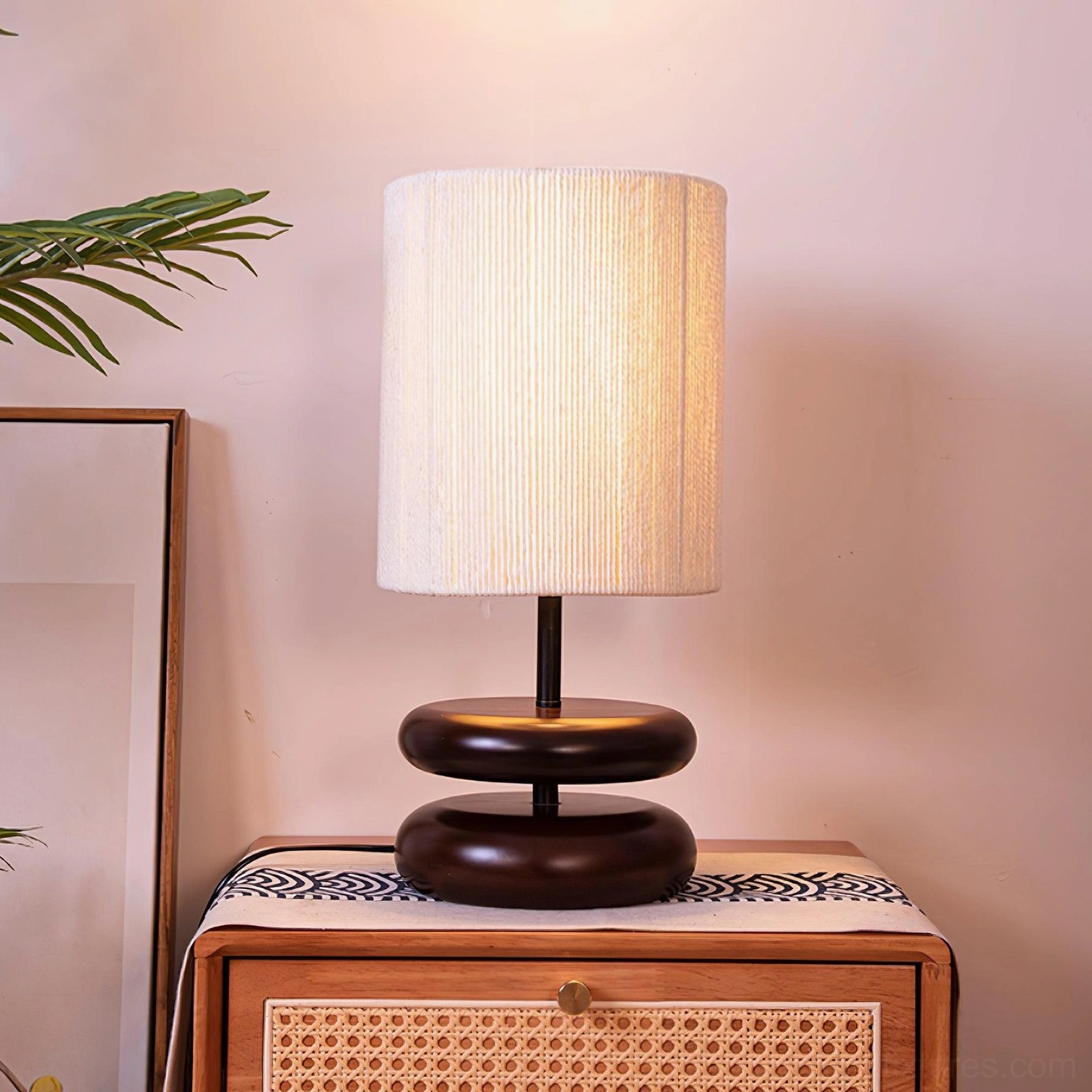 Walnut wood bedside table lamp on nightstand with rattan furniture in boho bedroom
