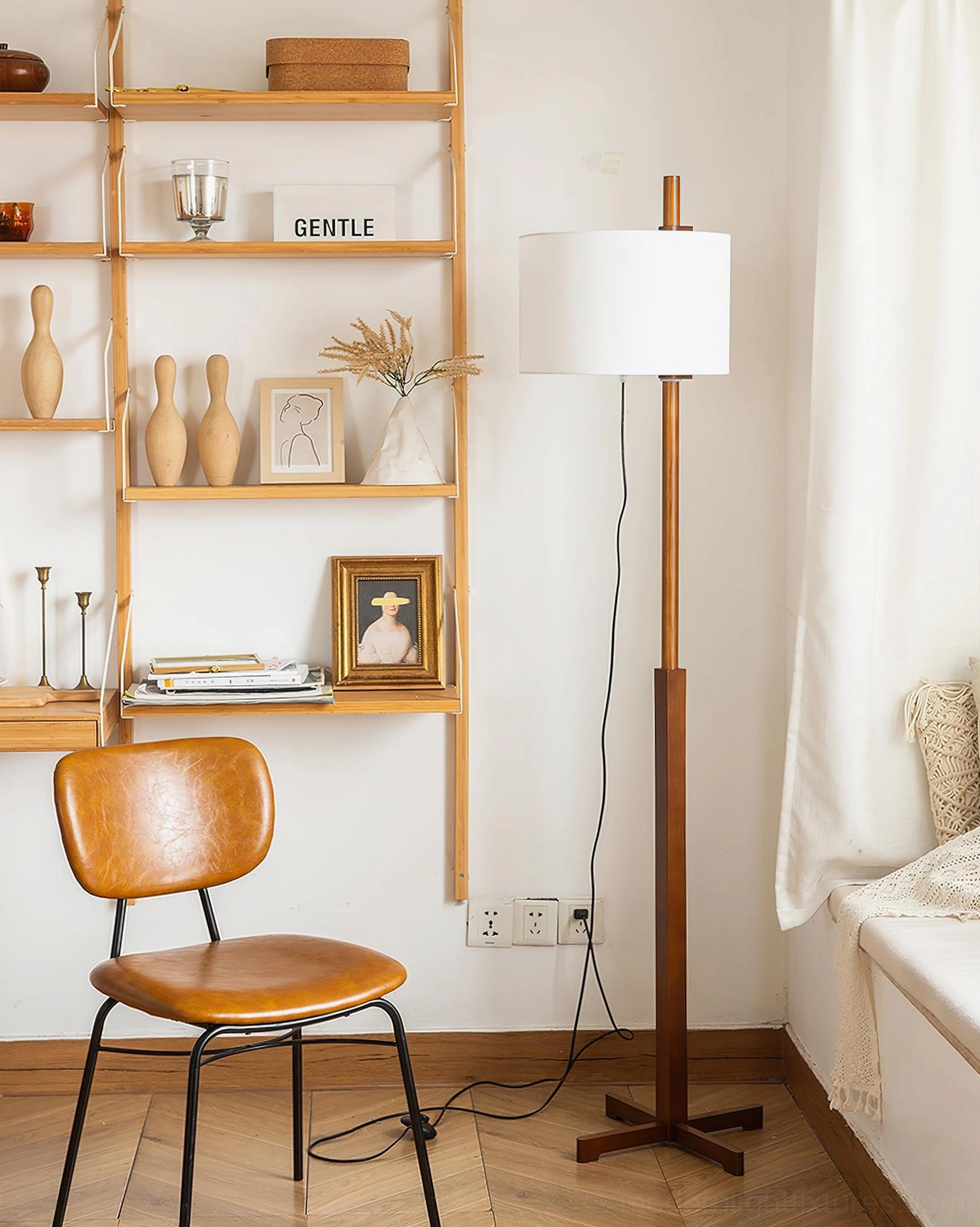 Minimalist walnut floor lamp side view next to brown leather dining chair in bright window setting