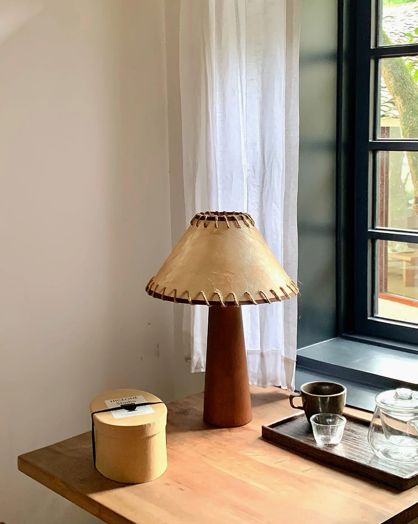 Walnut wood base lamp with textured jute shade highlighting natural materials and organic design aesthetic