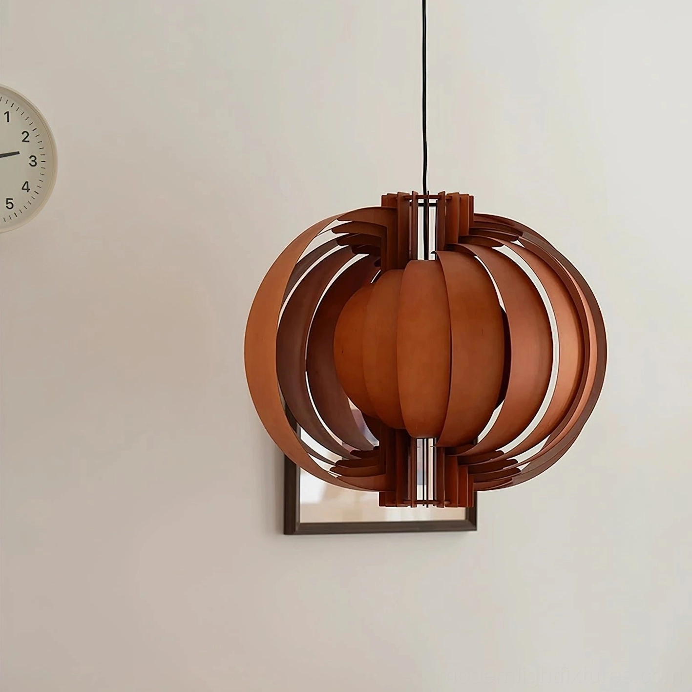 Walnut brown wooden spherical pendant lamp in mid-century modern style, three-quarter view with wall decor