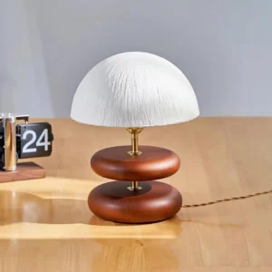 Walnut finish wood ring table lamp with brass metal details on wooden desk contemporary interior setting
