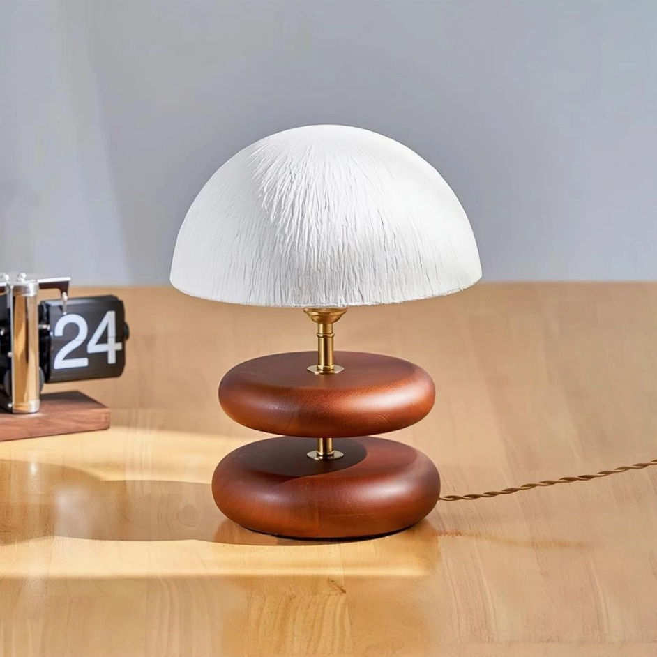 Walnut finish wood ring table lamp with brass metal details on wooden desk contemporary interior setting