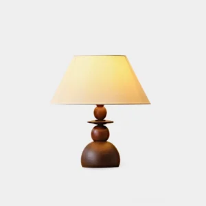 Walnut wood table lamp with beige fabric shade on white background, showing stacked wooden base and clean modern design