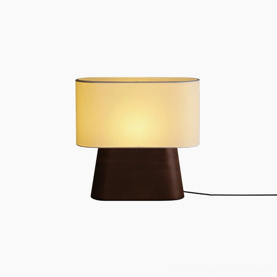 Walnut color wood table lamp with white fabric shade providing warm bedside illumination