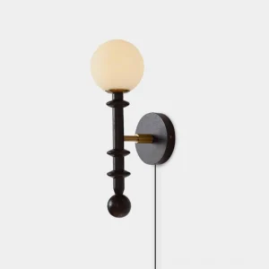 Walnut wood plug-in wall sconce with brass accents and frosted glass shade, front close-up view showing turned wooden beads detail
