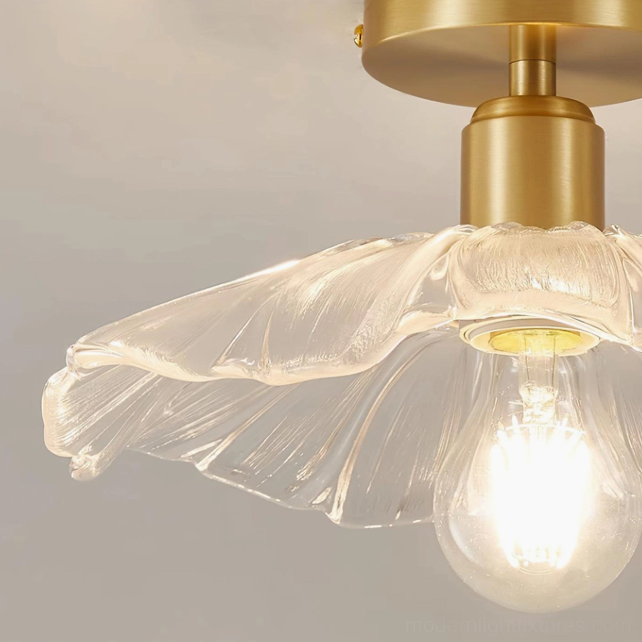 Semi-flush ruffled glass ceiling light with warm brass finish creating elegant ambient glow in interior space