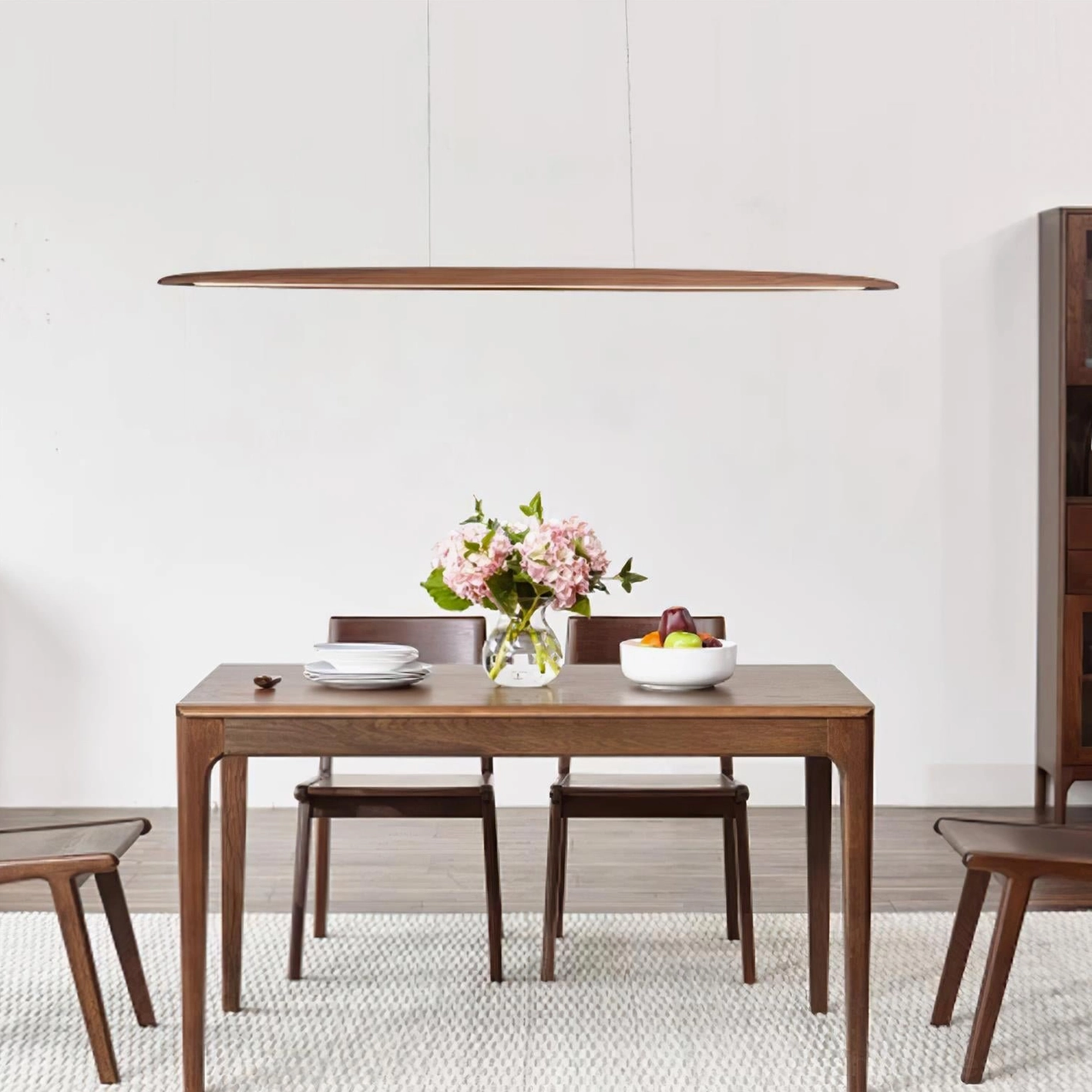 Warm family dining room with modern linear LED chandelier and fresh flower arrangement centerpiece