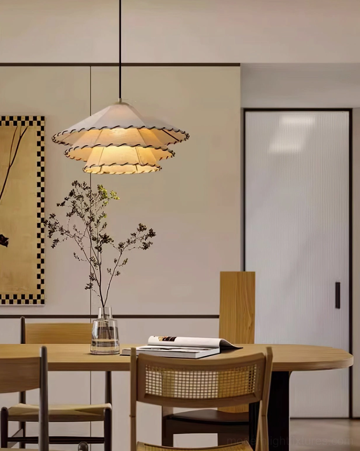 Handwoven fabric pendant lamp creating warm ambient lighting in cozy dining room with wall decor and flowers