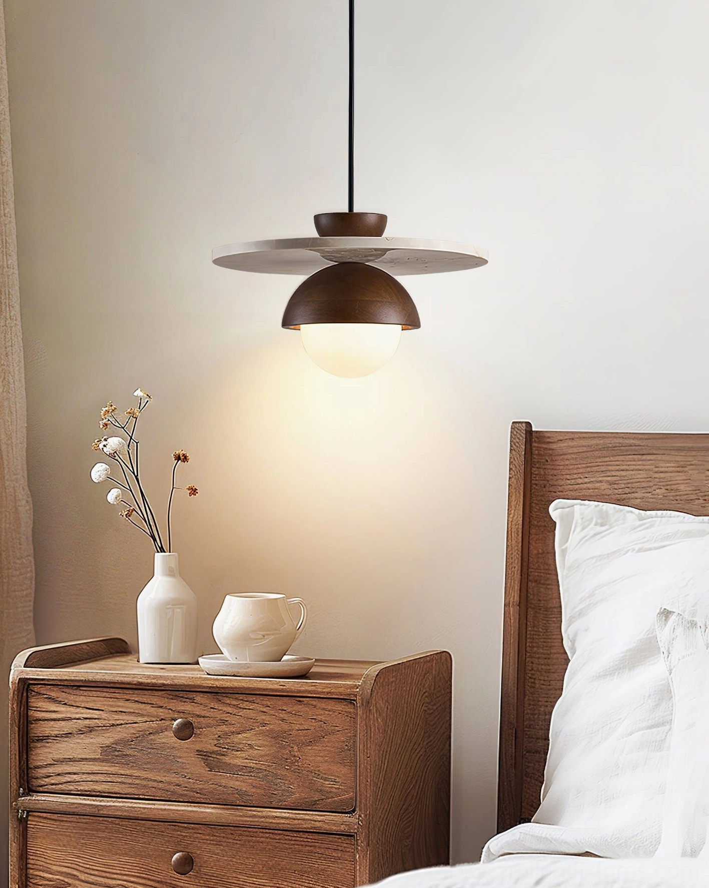 Glowing modern pendant lamp above wooden nightstand with warm LED bulb and bedroom decor