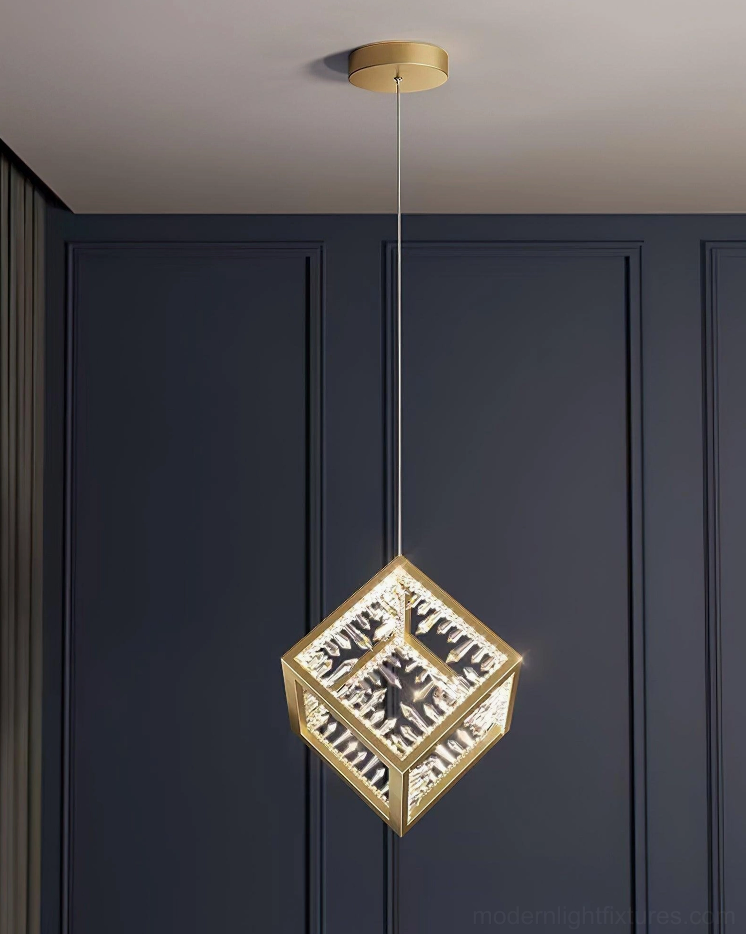 Gold Kristy cube pendant light with warm illumination showcasing intricate engraved interior panels
