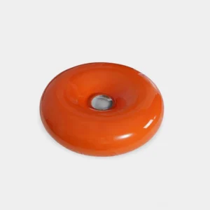 Warm orange donut table lamp front view on white background, smooth glossy glass with polished metal center detail