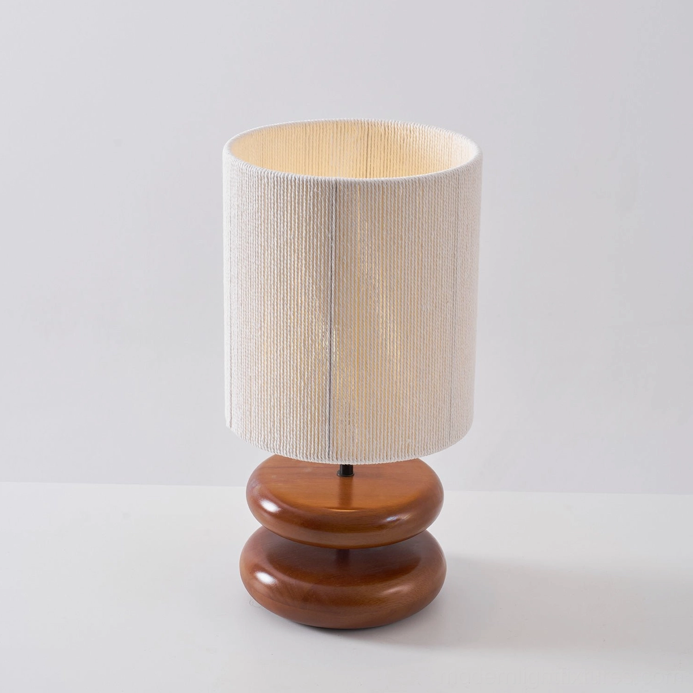 Warm wood toned table lamp with soft fabric shade for cozy bedroom atmosphere