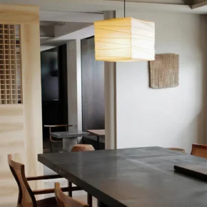 Japanese washi pendant light suspended in contemporary minimalist dining room with warm ambient glow