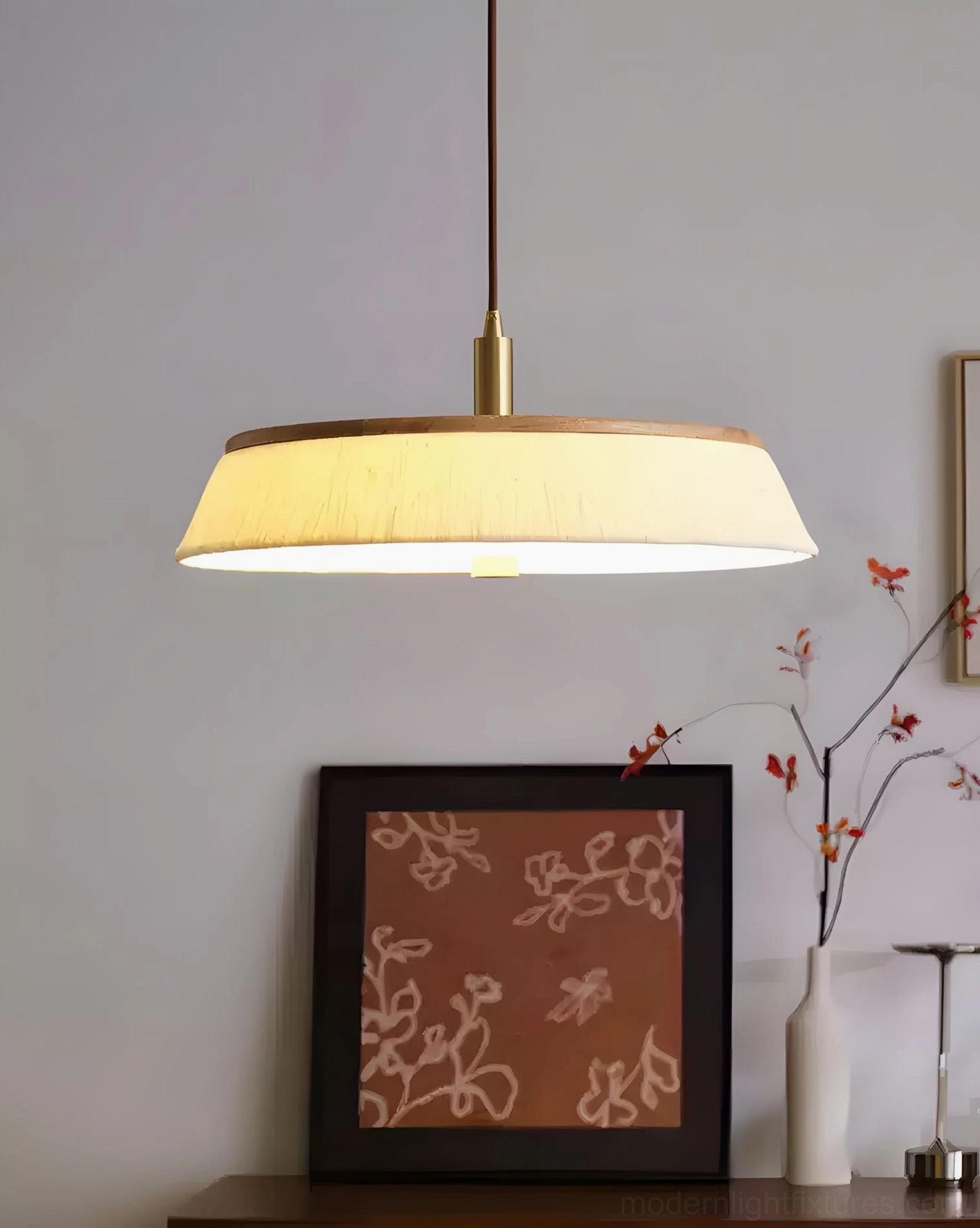 White rice paper pendant fixture in minimalist entryway with framed wall art and dried floral decor