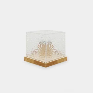 Modern water ripple crystal cube table lamp with wood base and clear textured glass, front three-quarter view showing embossed ripple pattern