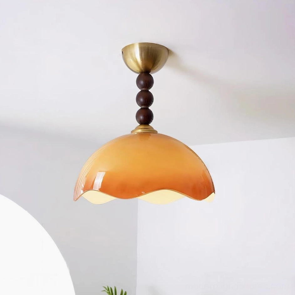 Gradient orange-brown wavy glass ceiling light fixture with brass mount and dark wooden bead stem