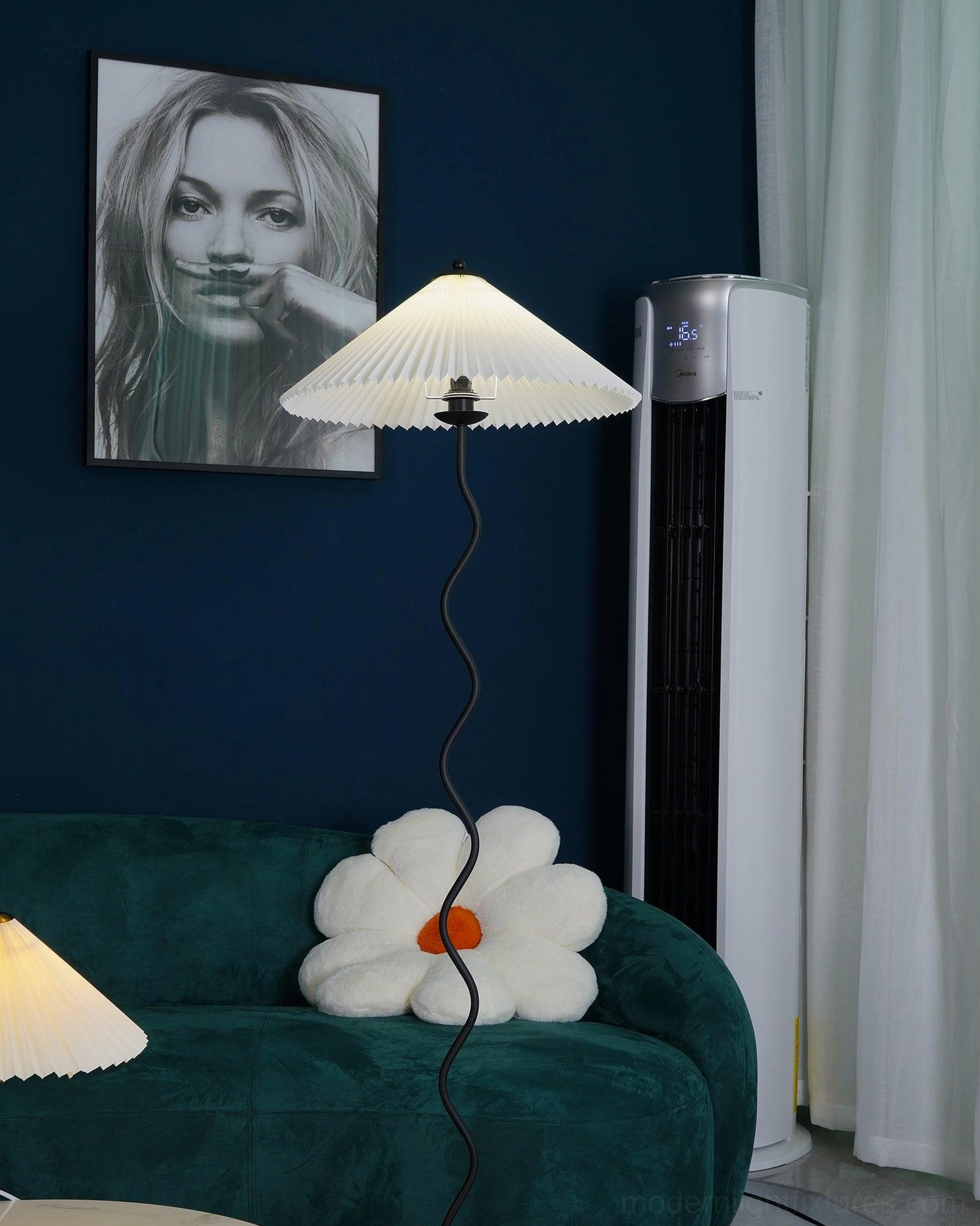 Contemporary wave floor lamp beside dark blue wall with portrait art and green sofa - modern interior design styling